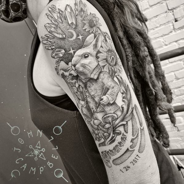 Upper arm alice in wonderland late rabbit tattoo. Book a custom tattoo with John at Sacred Mandala Studio - Durham, NC.